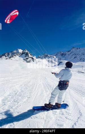 Uomo kiteboarding nella neve, Lermoos, Lechtaler Alpen, Tirolo, Austria Foto Stock