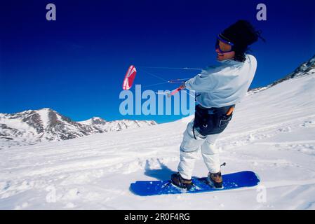 Uomo kiteboarding nella neve, Lermoos, Lechtaler Alpen, Tirolo, Austria Foto Stock