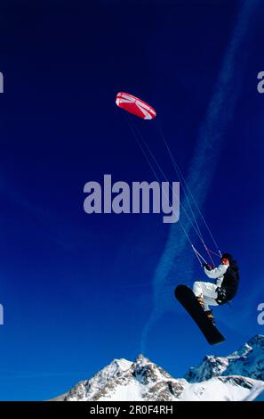 Uomo kiteboarding in neve, Jump, Lermoos, Lechtaler Alpen, Tirolo, Austria Foto Stock