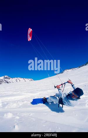 Uomo kiteboarding nella neve, Lermoos, Lechtaler Alpen, Tirolo, Austria Foto Stock