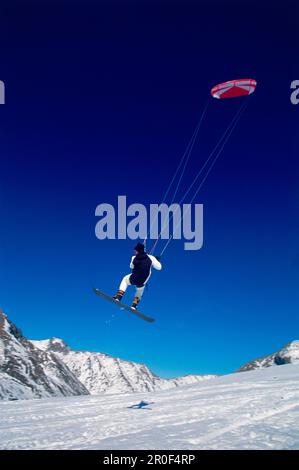 Uomo kiteboarding nella neve, Lermoos, Lechtaler Alpen, Tirolo, Austria Foto Stock