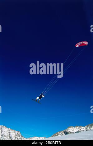 Uomo kiteboarding in neve, Jump, Lermoos, Lechtaler Alpen, Tirolo, Austria Foto Stock