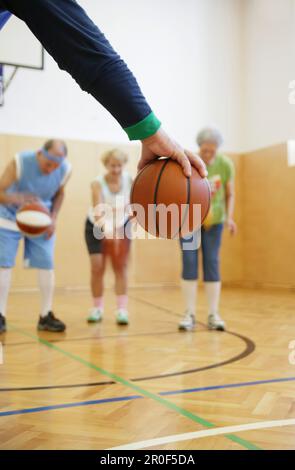 Persone mature che giocano a basket Foto Stock
