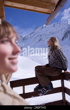 Due giovani donne a prendere il sole sulla terrazza del rifugio sciistico, Kuehtai, Tirolo, Austria Foto Stock