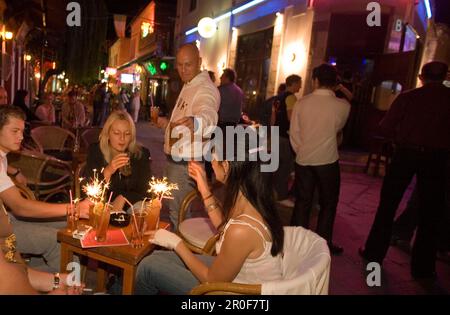 Il cameriere serve drink in un bar all'aperto di notte, Kos-Town, Kos, Grecia Foto Stock