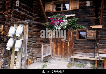 Lattine di latte e porta con decorazioni floreali, capanna Pehab, catena montuosa Dachstein, Salisburgo, Austria Foto Stock