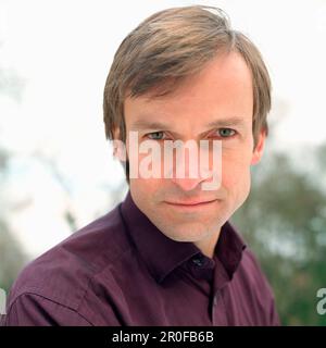 Uomo che guarda intenso alla fotocamera, ritratto Foto Stock
