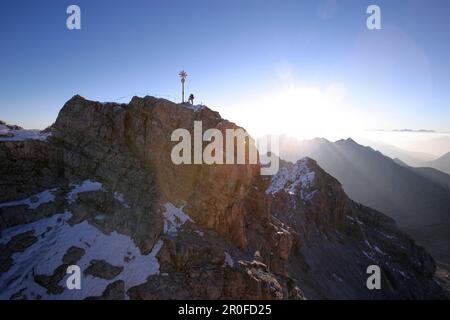 Uomo alla cima dello Zugspitze al mattino, Baviera, Germania Foto Stock