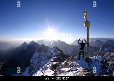 Uomo alla cima dello Zugspitze al mattino, Baviera, Germania Foto Stock