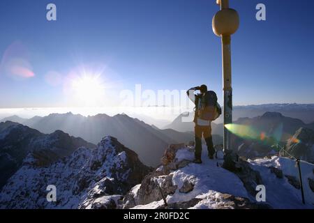 Uomo alla cima dello Zugspitze al mattino, Baviera, Germania Foto Stock