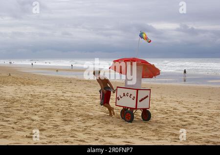 Giovane uomo che vende gelati alla spiaggia di Carcans Plage, dept Gironde, Francia, Europa Foto Stock