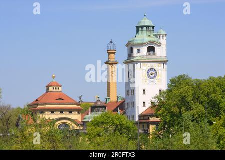 Tetto e torre dell'acqua di Müllersches Volksbad sulle cime degli alberi, Monaco, Baviera, Germania Foto Stock