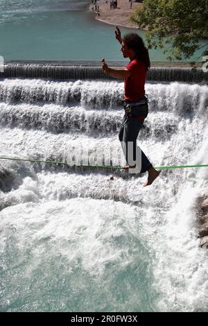 Giovane uomo in corda su un fiume, Fussen, Baviera, Germania Foto Stock