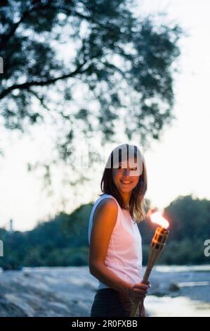 Giovane donna che regge la torcia, Monaco, Baviera, Germania Foto Stock