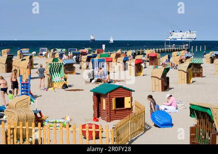 Vacanzieri che si rilassano in sedie a sdraio in spiaggia, Travemunde, Lubecca, Schleswig-Holstein, Germania Foto Stock