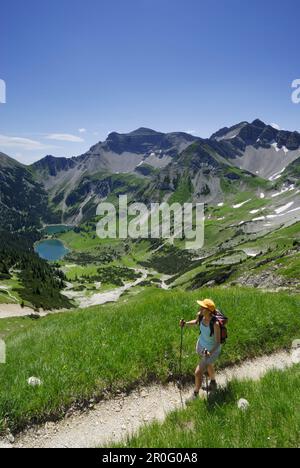 Donna escursioni sopra i laghi Soiernseen, Soiernspitze in background, catena del Karwendel, Baviera, Germania Foto Stock