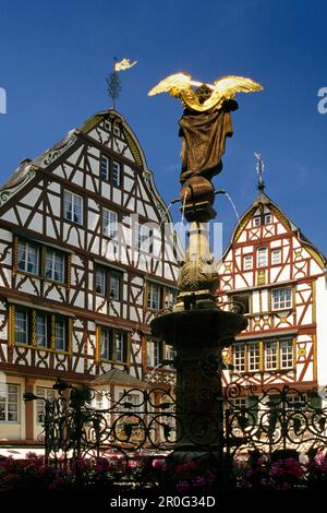 Scultura su una fontana e case a graticcio sotto il cielo blu, Bernkastel-Kues, Renania-Palatinato, Germania Foto Stock