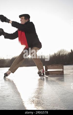 Persona che aiuta il pattinatore di ghiaccio a alzarsi, Lago Ammersee, alta Baviera, Germania Foto Stock