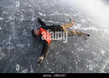 Pattinatore su ghiaccio giacente su ghiaccio, Lago Ammersee, Alta Baviera, Germania Foto Stock