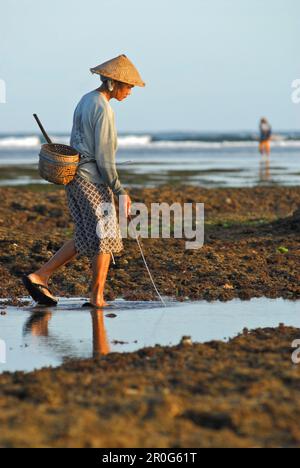 Un pescatore a hte spiaggia con la bassa marea, pura Geger, Bali meridionale, Indonesia, Asia Foto Stock