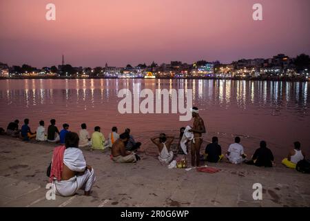 La gente baga nel lago di Pushkar al tramonto, Pushkar, Rajasthan, India Foto Stock