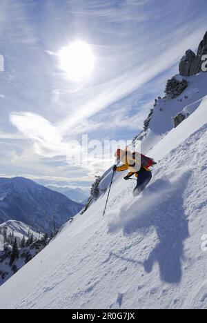 Donna sciare in discesa attraverso la neve, la gamma Mangfall, l'alta Baviera, Baviera, Germania Foto Stock