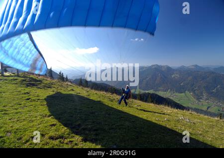 Persona parapendio vicino al lago Tegernsee, vicino Rottach-Egern, Tegernsee, Alta Baviera, Baviera, Germania Foto Stock