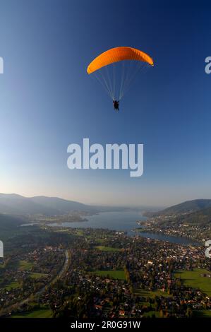 Persona parapendio vicino al lago Tegernsee, vicino Rottach-Egern, Tegernsee, Alta Baviera, Baviera, Germania Foto Stock