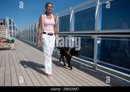 Crociera, Queen Mary 2, passeggeri tenendo il suo cane per una passeggiata sul ponte sole, Transatlantic Foto Stock