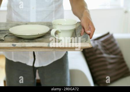 Uomo che tiene un vassoio con piatti, Stiria, Austria Foto Stock