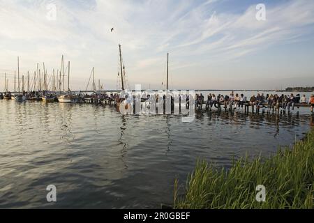 Persone sedute sul molo del lago Steinhude, bassa Sassonia, Germania Foto Stock