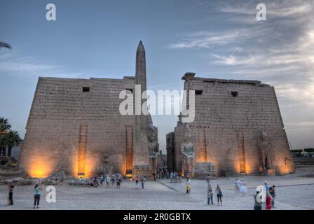 Ingresso illuminato del Tempio di Luxor con il Tempio di Ramesses II statua e obelisco di Luxor, Egitto Foto Stock