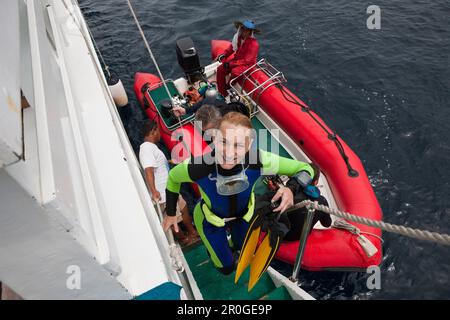 Diver entra Liveabord dopo le immersioni, Raja Ampat, Papua occidentale, in Indonesia Foto Stock