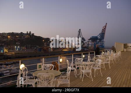 Sedie sul ponte della nave da crociera MS Deutschland (Deilmann Cruises) e gru portuali al crepuscolo, Valparaiso, Cile, Sud America, America Foto Stock