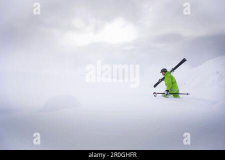 Libera maschio sciatore ascendente nella neve profonda, Mayrhofen, Valle Ziller, Tirolo, Austria Foto Stock