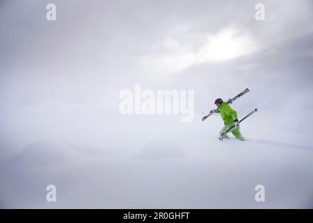 Libera maschio sciatore ascendente nella neve profonda, Mayrhofen, Valle Ziller, Tirolo, Austria Foto Stock