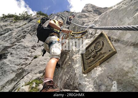 Vista ad angolo basso in coppia sulla parete rocciosa, Schuasta Gangl, percorso a corda fissa Gamsteig, Steinplatte, Reit im Winkl, Chiemgau, alta Baviera, Baviera, Germa Foto Stock