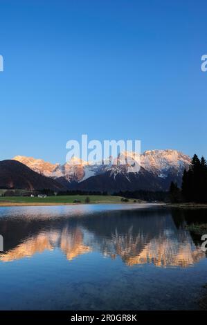 La catena del Karwendel, coperta di neve, si riflette in un lago di montagna, Kruen, Werdenfelser Land, Alpi bavaresi, alta Baviera, Baviera, Germania Foto Stock