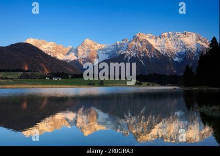 La catena del Karwendel innevata che si riflette in un lago di montagna, Kruen, Werdenfelser Land, Alpi bavaresi, alta Baviera, Baviera, Germania Foto Stock