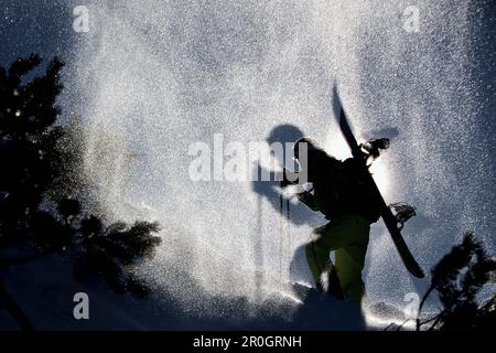 Snowboarder in salita attraverso la neve profonda, Oberjoch, Bad Hindelang, Baviera, Germania Foto Stock