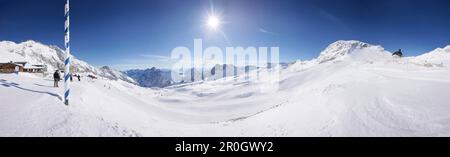 Sciatori sull'altopiano di Zugspitzplateau, ristorante sul ghiacciaio Sonnalpin sullo sfondo, Zugspitze, alta Baviera, Baviera, Germania Foto Stock