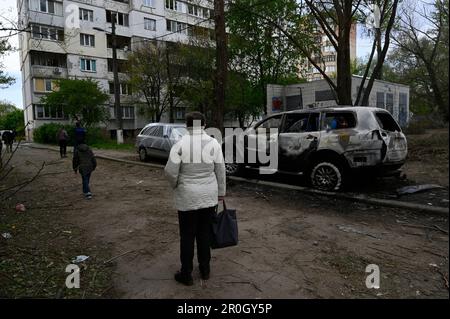 Kiev, Ucraina. 08th maggio, 2023. Una donna guarda le auto danneggiate da frammenti di un drone kamikaze abbattuto dell'esercito russo. La notte del 8 maggio, l'esercito russo ha attaccato la regione di Kyiv con droni d'urto iraniani 'Shahed'. L'esercito ucraino ha distrutto 35 fuchi russi su 35 sparati a Kyiv. In città, a causa della caduta di detriti, case, superfici stradali e automobili sono stati danneggiati. Cinque persone sono rimaste ferite. (Foto di Sergei Chuzavkov/SOPA Images/Sipa USA) Credit: Sipa USA/Alamy Live News Foto Stock