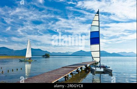 Catamarano accanto al molo al lago Chiemsee, Schuetzing, Chieming, Chiemgau, Alta Baviera, Germania Foto Stock