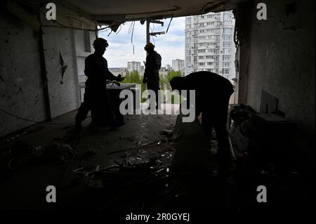 Kiev, Ucraina. 08th maggio, 2023. Soccorritori visti in un edificio residenziale a più piani danneggiato da uno shrapnel da un drone kamikaze abbattuto dell'esercito russo. La notte del 8 maggio, l'esercito russo ha attaccato la regione di Kyiv con droni d'urto iraniani 'Shahed'. L'esercito ucraino ha distrutto 35 fuchi russi su 35 sparati a Kyiv. In città, a causa della caduta di detriti, case, superfici stradali e automobili sono stati danneggiati. Cinque persone sono rimaste ferite. (Foto di Sergei Chuzavkov/SOPA Images/Sipa USA) Credit: Sipa USA/Alamy Live News Foto Stock