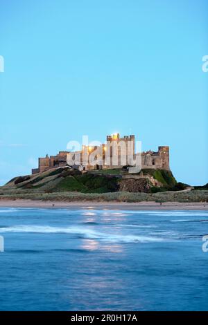 La costa sotto il Castello di Bamburgh in serata, Bamburgh, Northumberland, Inghilterra, Gran Bretagna, Europa Foto Stock
