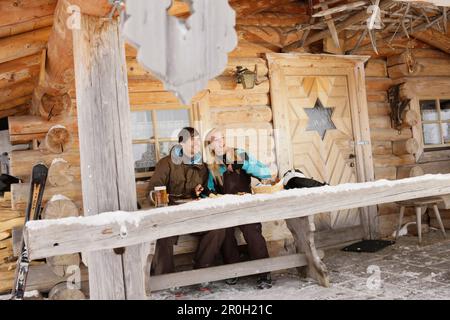 Giovane coppia di fronte al rifugio, Idealhang, Brauneck, Toelzer Land, Baviera, Germania, Europa Foto Stock