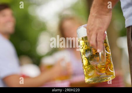 Mano che tiene un stein in una birreria all'aperto, Monaco, Baviera, Germania, Europa Foto Stock
