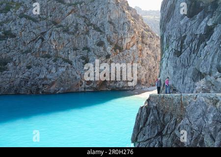 Escursionisti sopra la baia di SA Calobra, Cala de SA Calobra, fine del canyon Torrent de Pareis, spiaggia romantica, Serra de Tramuntana, UNESCO World Cultura Foto Stock