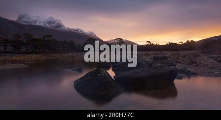 Alba sopra le Highlands nordoccidentali con la vista sulla cima di Slioch e Loch Maree in primo piano, Scozia, Regno Unito Foto Stock