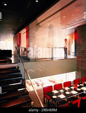 MESSICO, Città del Messico, giovane donna in piedi nella lobby illuminata del ristorante del W Hotel. Foto Stock